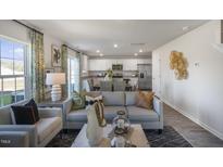 Bright, open-concept living room seamlessly flows into kitchen and dining area for easy entertaining at 2156 Monk Dr, Haw River, NC 27258