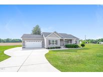 Charming single-story home featuring a manicured lawn, attached garage, and traditional architectural details at 24 Cider Ct, Benson, NC 27504