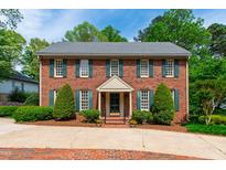 Charming brick two-story home with green shutters and manicured landscaping at 2720 Townedge Ct, Raleigh, NC 27612