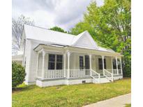 Charming exterior view of a two-story home featuring a welcoming front porch and well-maintained yard at 305 N Webb St, Selma, NC 27576