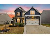Charming two-story home with a stone facade, two-car garage, beautiful landscaping, and inviting curb appeal at 361 W Copenhaver Dr, Clayton, NC 27527