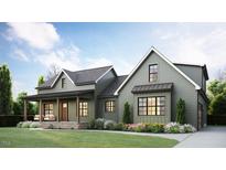 Charming two-story home with a covered porch, landscaped yard, and neutral siding creating curb appeal at 435 Pilot Ridge Rd, Zebulon, NC 27597