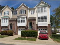 Attractive townhome features a well-manicured lawn, brick accents, and a single-car garage for convenient parking at 4502 Pale Moss Dr. Dr, Raleigh, NC 27606