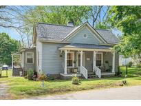Charming home with a well-maintained lawn, quaint porch, and inviting curb appeal at 726 Elizabeth Ave, Wake Forest, NC 27587