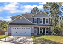 Charming two-story home featuring a well-manicured lawn, two-car garage, and inviting covered front porch at 78 Parkview Ln, Lillington, NC 27546