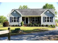 Charming single-story home with gray siding, black shutters, and a well-manicured lawn at 860 Bear Rd, Benson, NC 27504
