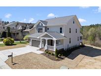 Charming two-story home featuring a covered porch, attached garage, and manicured landscaping at 10119 Second Star Ct, Raleigh, NC 27613