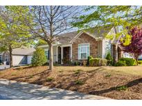 Charming home featuring stone and siding exterior with manicured landscaping and mature trees at 1064 Blue Bird Ln, Wake Forest, NC 27587