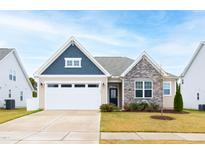 Charming single-Gathering home featuring stone accents, a two-car garage, and a well-manicured lawn at 124 Alta Crest Ln, Garner, NC 27529
