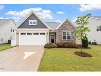 Charming home featuring a two-car garage and stone accents, complemented by a well-maintained lawn and landscape at 124 Alta Crest Ln, Garner, NC 27529