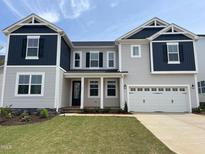 Two-story home with gray siding, dark blue accents, a well-kept lawn, and attached two car garage at 159 Yellow River Way, Garner, NC 27529