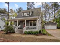 Charming home boasts a cozy porch, white railings, and a vibrant red door at 2007 Watson Rd, Durham, NC 27704