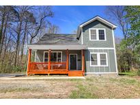 Charming home featuring a welcoming front porch with sturdy columns and new paint at 218 Archdale Dr, Durham, NC 27707