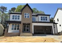 Two-story home with large windows, brick accents, and an attached two-car garage in a well-lit area at 3412 Amelia Grace Dr # 43, Fuquay Varina, NC 27526