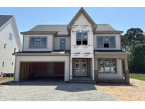 Under-construction two-story home featuring a two-car garage and a classic facade at 3516 Amelia Grace Dr # 31, Fuquay Varina, NC 27526