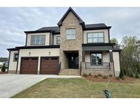 Two-story home boasts a two-car garage, brick accents, covered porch, and professionally landscaped yard at 3601 Amelia Grace Dr # 18, Fuquay Varina, NC 27526