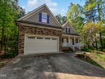 Charming home featuring a stone facade, attached two-car garage, covered porch and lovely curb appeal at 3638 Pine Needles Dr, Wake Forest, NC 27587