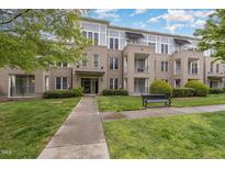 Attractive condo building with manicured lawn, walkway, and bench offers a comfortable and inviting place to live at 501 Finsbury Street # 103, Durham, NC 27703