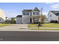 Charming two-story home featuring a well-manicured lawn and a two-car attached garage at 624 S Kennelman Cir, Wendell, NC 27591
