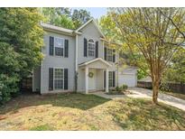 Charming two-story home features a manicured front yard and attached garage at 9904 Erinsbrook Dr, Raleigh, NC 27617
