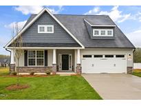 Charming home with a well-manicured lawn, stone accents, and a two-car garage at 1073 Fairhaven Dr # 52, Mebane, NC 27302