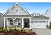 Charming home featuring a covered porch, two-car garage, and well-maintained landscaping at 1116 Ciandra Barn Way, Apex, NC 27523