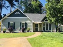 Charming single-story home with a well-maintained lawn, lush landscaping, and a welcoming walkway to the front door at 117 Buena Vista Dr, Cary, NC 27513