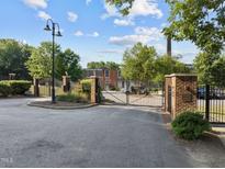 Gated community entrance with brick pillars and manicured landscaping under a sunny sky at 1535 Caraleigh Mills Ct # 104, Raleigh, NC 27603