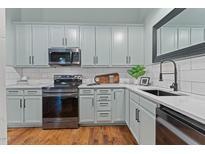 Well-lit kitchen with updated appliances, sleek countertops, and ample cabinet space at 1535 Caraleigh Mills Ct # 104, Raleigh, NC 27603