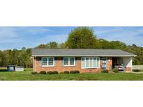 Charming brick ranch home with manicured lawn and attached carport providing functional curb appeal at 1829 Stewart Farm Rd, Henderson, NC 27537