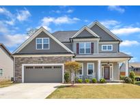 Charming two-story home featuring a stone facade, gray siding, and a well-manicured lawn at 350 Stephens Way, Youngsville, NC 27596