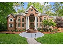 Stately brick home featuring a grand entrance with white columns and manicured landscaping at 417 Swans Mill Xing, Raleigh, NC 27614