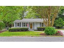 Charming single-story home with gray siding, mature trees, manicured lawn, and welcoming front porch at 423 N Main St, Wendell, NC 27591
