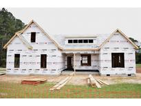 Exterior construction of a new home with protective wrap, showcasing the framing and initial stages of building at 4330 Medicus Ln, Franklinton, NC 27525