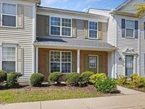 Charming townhouse featuring a brick facade, green shutters, and well-maintained landscaping at 5044 Brooke Lauren Ln, Raleigh, NC 27616