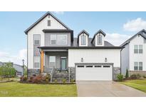 Beautiful two-story home featuring a two-car garage, stone accents, and a welcoming front porch at 5616 Horsewalk Cir, Raleigh, NC 27606
