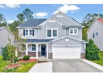 Charming two-story home with gray siding, a well-manicured lawn, and attached two car garage at 619 Ashburn Ln, Durham, NC 27703