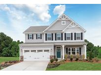 Charming two-story home featuring a two-car garage, manicured lawn, and classic architectural details at 809 Walker Ridge Way, Willow Springs, NC 27592