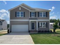 Charming two-story home with a large garage, well-maintained lawn, and neutral-colored siding under a bright, sunny sky at 84 Grove Township Way, Angier, NC 27501