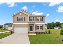 Charming two-story home with neutral siding, a two-car garage, and a well-maintained front yard at 84 Grove Township Way, Angier, NC 27501