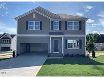 Charming two-story home with an attached carport, a well-manicured lawn and classic curb appeal at 84 Grove Township Way, Angier, NC 27501