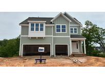 Two-story home features a two-car garage, light green siding and white trim at 107 Berry Mill Ln # 134, Raleigh, NC 27603