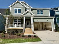 Charming two-story home with an attached garage, porch and manicured front yard at 1245 Porters Call Dr, Wendell, NC 27591