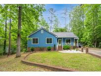 Charming single-story home with blue siding, a metal roof, a yellow front door, and attractive landscaping at 1487 Kentucky Ave, Sanford, NC 27332