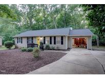Charming ranch home with a yellow front door, black shutters, and an attached one-car garage at 1536 Dirkson Ct, Cary, NC 27511