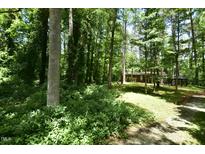 Secluded single story brick home with mature trees and landscaping on a wooded lot at 208 Clark Lake Rd, Durham, NC 27707