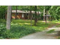Charming one story brick home with a front yard surrounded by beautiful mature trees at 208 Clark Lake Rd, Durham, NC 27707
