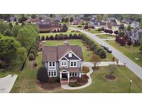 Inviting two-story home with beautifully landscaped front yard and charming front porch in a desirable neighborhood at 2113 Rockwall Farms Ln, Fuquay Varina, NC 27526