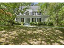 Charming two-story home featuring a welcoming front porch surrounded by mature trees and lush landscaping at 216 Dairyland Rd, Chapel Hill, NC 27516