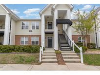 Inviting exterior view of a two-story condo building, boasting well-maintained landscaping and charming architectural details at 2411 Vancastle Way # 202, Raleigh, NC 27617